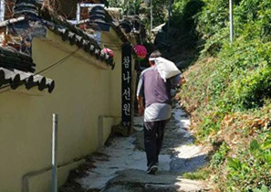 배달원이 산길을 따라 양곡을 메고 배달하는 사진